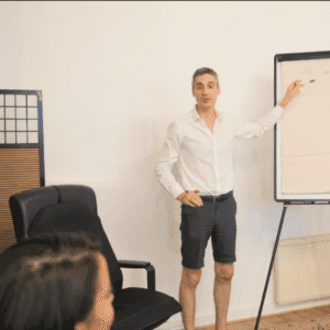 Xavier Foucher animant un atelier de développement personnel à Paris devant un tableau lors d'une séance de groupe