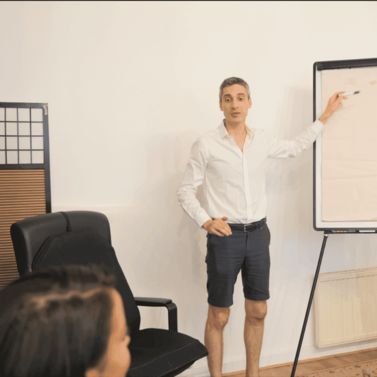 Xavier Foucher animant un atelier de développement personnel à Paris devant un tableau lors d'une séance de groupe